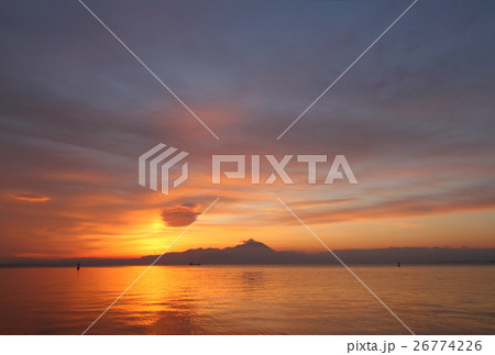 日の出の大山と朝焼けに染まる空と海の写真素材
