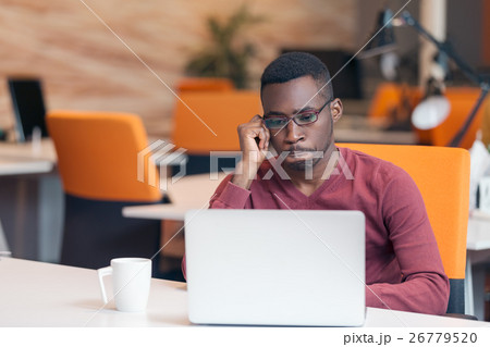 Handsome African American looking at the screen Handsome African American looking at the screen 26779520