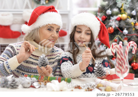 Grandmother with child preparing for Christmas Grandmother with child preparing for Christmas 26779553