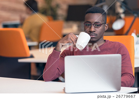 Cheerful young African businessman typing looking 26779667