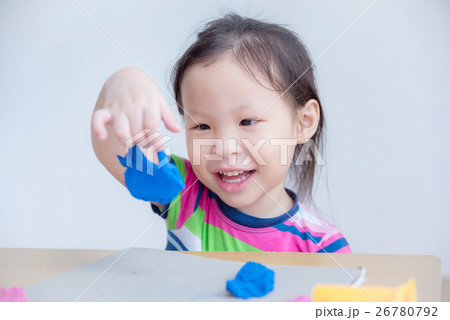 Little asian girl playing with dough on table Little asian girl playing with dough on table 26780792