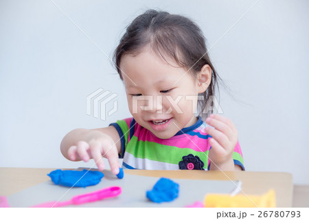 Little asian girl playing with dough on table Little asian girl playing with dough on table 26780793