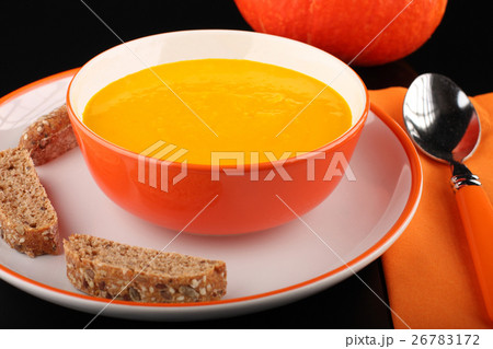 bowl of pumpkin hokkaido soup with bread on black 26783172