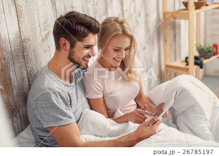 Happy man and woman with computer in bedroom 26785197