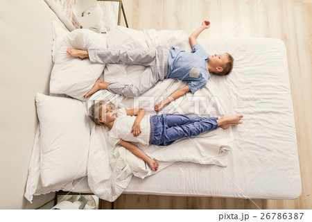 Brother and sister sleeping at home 26786387