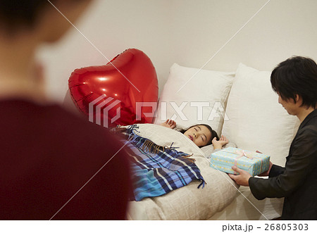 枕元にプレゼントを置く両親の写真素材