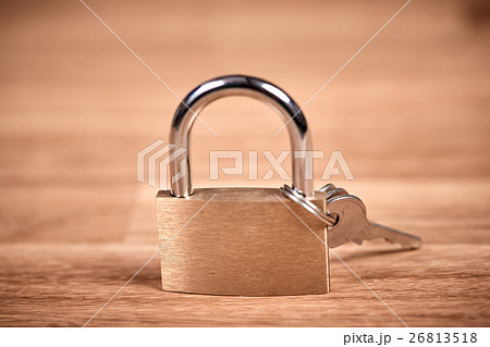 Padlock and keys on a brown wooden table Padlock and keys on a brown wooden table 26813518