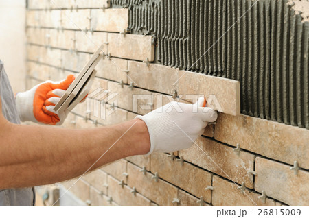 Installing the tiles on the wall. 26815009
