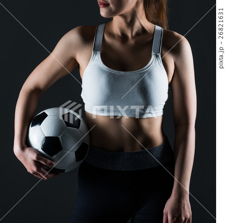 Beautiful woman holding a football gray background 26821631