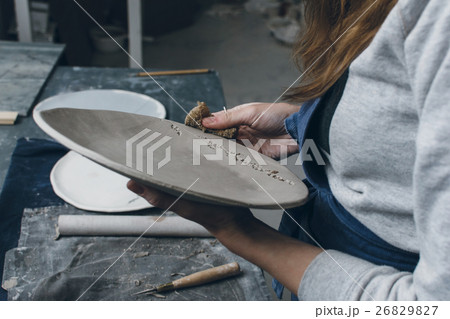 Ceramist finishing a plate Ceramist finishing a plate 26829827