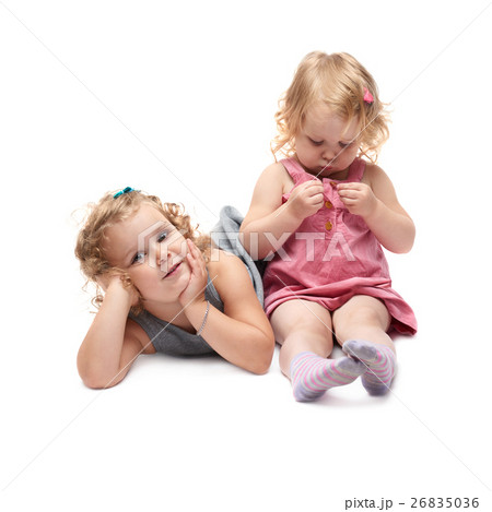 Couple of young little girl sitting over isolated Couple of young little girl sitting over isolated 26835036