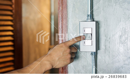 Man turning on or off on a light switch. Man turning on or off on a light switch. 26839683