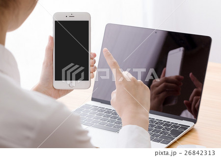 ノートパソコンを使う女性、窓際、スマートフォン、携帯電話、スワイプ ノートパソコンを使う女性、窓際、スマートフォン、携帯電話、スワイプ 26842313