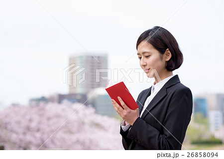 桜を背に手帳を確認する新入社員の女性　ビジネスウーマン 26858094