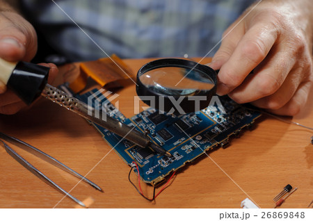 Senior engineer soldering computer board Senior engineer soldering computer board 26869848