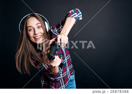 Positive young woman holding game console Positive young woman holding game console 26878388