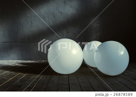 Three big balloons lying in the dark lighted room 26878589