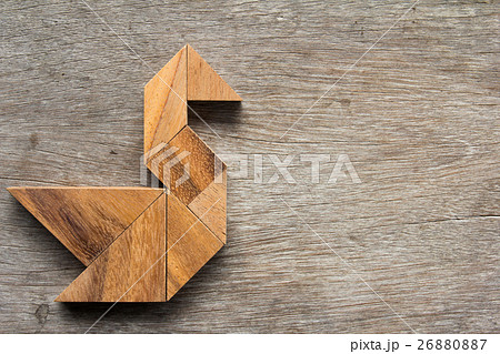 Wooden tangram as bird shape on wood background Wooden tangram as bird shape on wood background 26880887