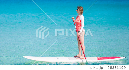 woman stand up paddling woman stand up paddling 26881199
