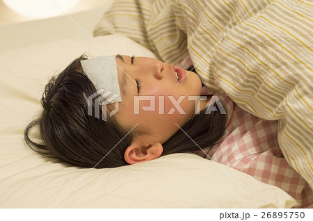 カゼで寝ている女の子の写真素材