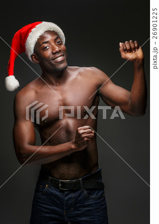 Muscular black shirtless young man in Santa Claus Muscular black shirtless young man in Santa Claus 26901225