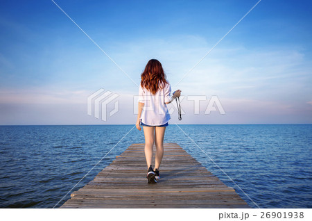 Woman walking on wooden bridge. Woman walking on wooden bridge. 26901938