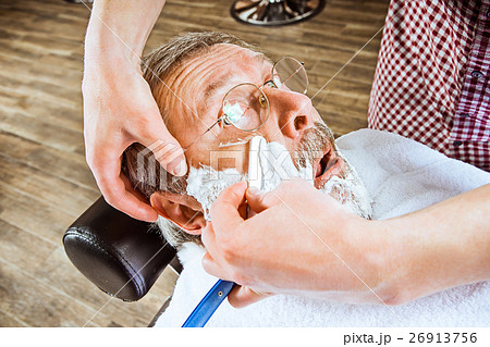 The senior man visiting hairstylist in barber shop 26913756