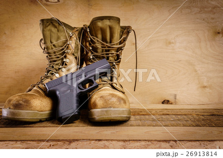 military boots and gun on the table 26913814