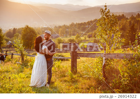 loving couple in the mountains near a wooden fence loving couple in the mountains near a wooden fence 26914322