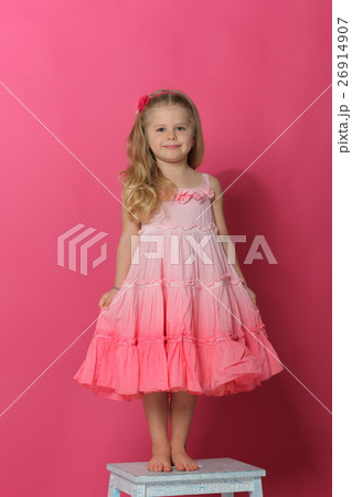 Little lady in dress standing on chair. Pink 26914907
