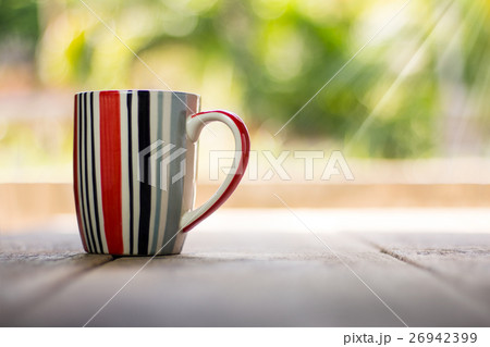 Striped cup on wooden background 26942399
