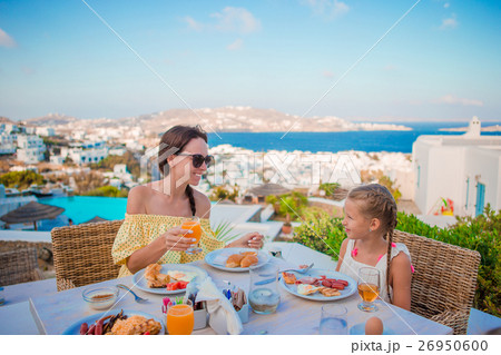 Family having breakfast at outdoor cafe with 26950600