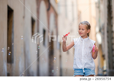 Adorable little girl outdoors blowing soap bubbles 26950754