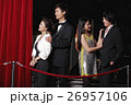 Young people standing behind red rope at night 26957106