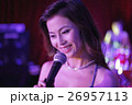 Young woman singing into a microphone at night 26957113