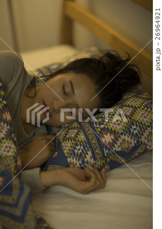ベッドで眠る若い女性 26964921
