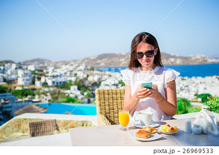 Beautiful elegant lady on breakfast with phone at 26969533