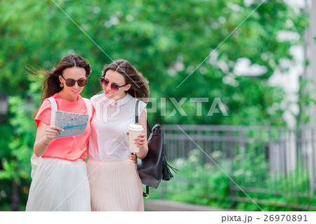 Happy young women with touristic map walking along 26970891