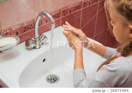 Girl thoroughly wash their hands with soap and water 26972464