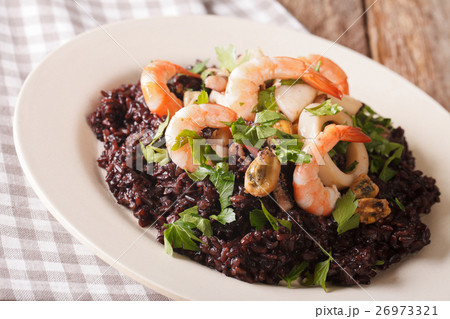 Paella from black rice with seafood close-up 26973321