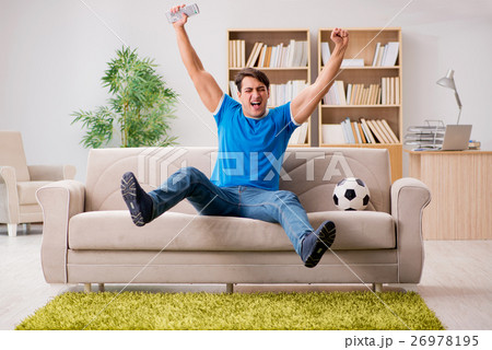 Man watching football at home 26978195