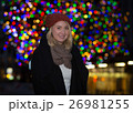 Beautiful young woman with christmas tree in the background 26981255