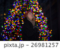Beautiful young woman with christmas tree in the background 26981257