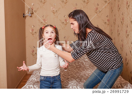 Mother trying to strangle her little daughter. Mother trying to strangle her little daughter. 26991729