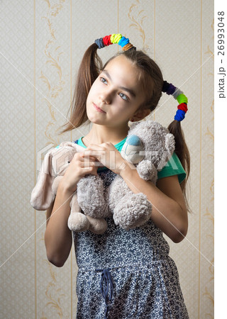 girl with two soft toys dreamily looking up 26993048
