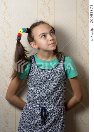 girl is leaning against the wall and looks up girl is leaning against the wall and looks up 26993373