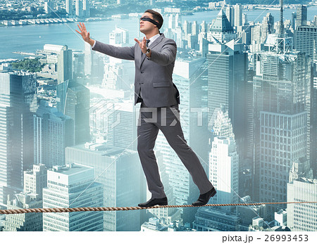 Man walking in tight rope blindfold 26993453