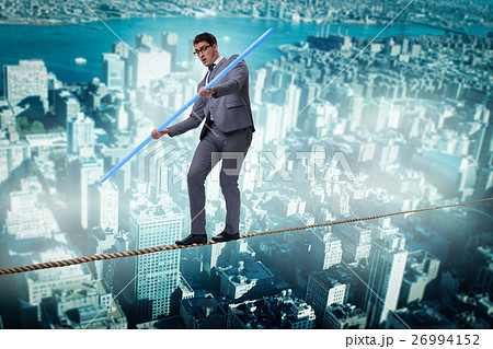 Businessman doing tightrope walking in risk Businessman doing tightrope walking in risk 26994152