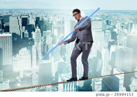 Businessman doing tightrope walking in risk Businessman doing tightrope walking in risk 26994153