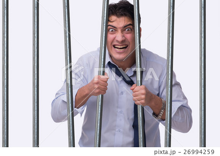 Young businessman behind the bars in prison Young businessman behind the bars in prison 26994259